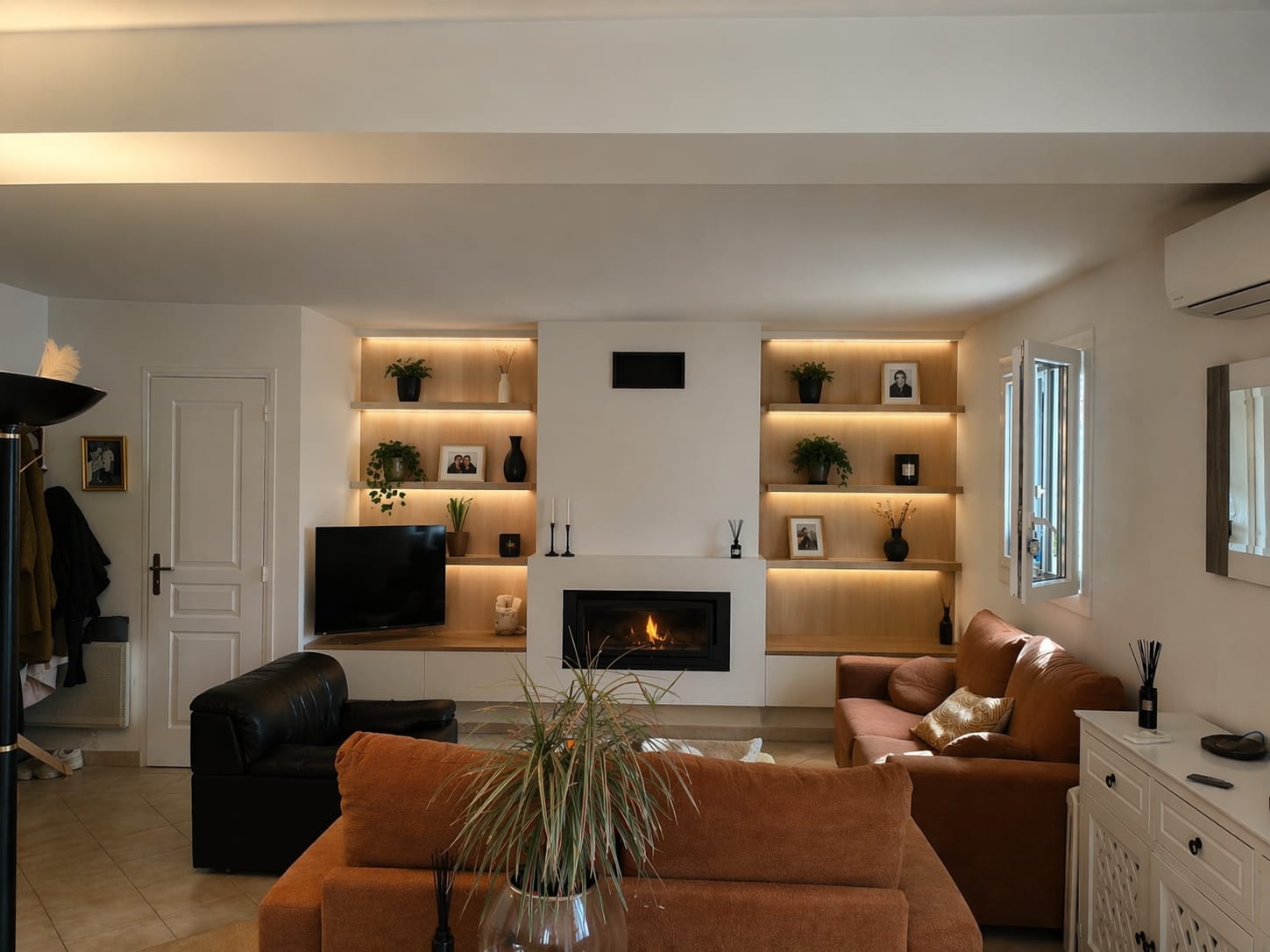 Salon avec étagères en bois rétroéclairées et cheminée, réalisé par Irimia Rénovation